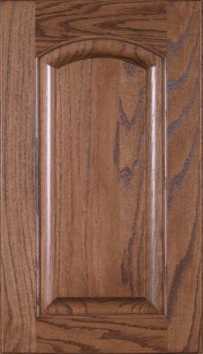 Eclipse Crown Raised Panel, A wooden cabinet door with a raised center panel and arched top. The wood grain is visible, and the finish is a medium brown. The edges are beveled, giving the door a classic, traditional look