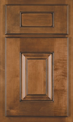 Shiloh Summit, A wooden cabinet door from Bethesda Cabinets with a warm brown finish, featuring a raised central panel and decorative molding. The top section has a smaller rectangular panel, while the bottom highlights a larger, detailed inset panel