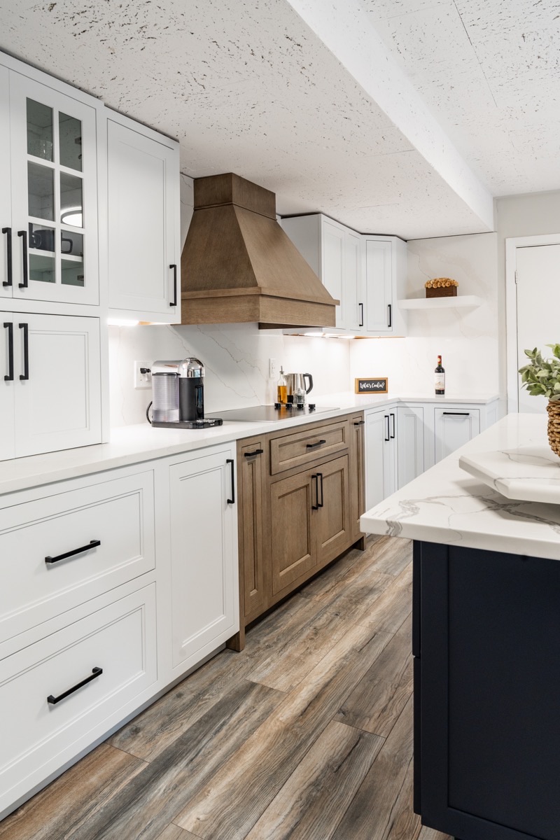 Kitchen display at the Bethesda Cabinets showroom with Eclipse cabinetry, white upper cabinets, wood lowers, and a marble island.