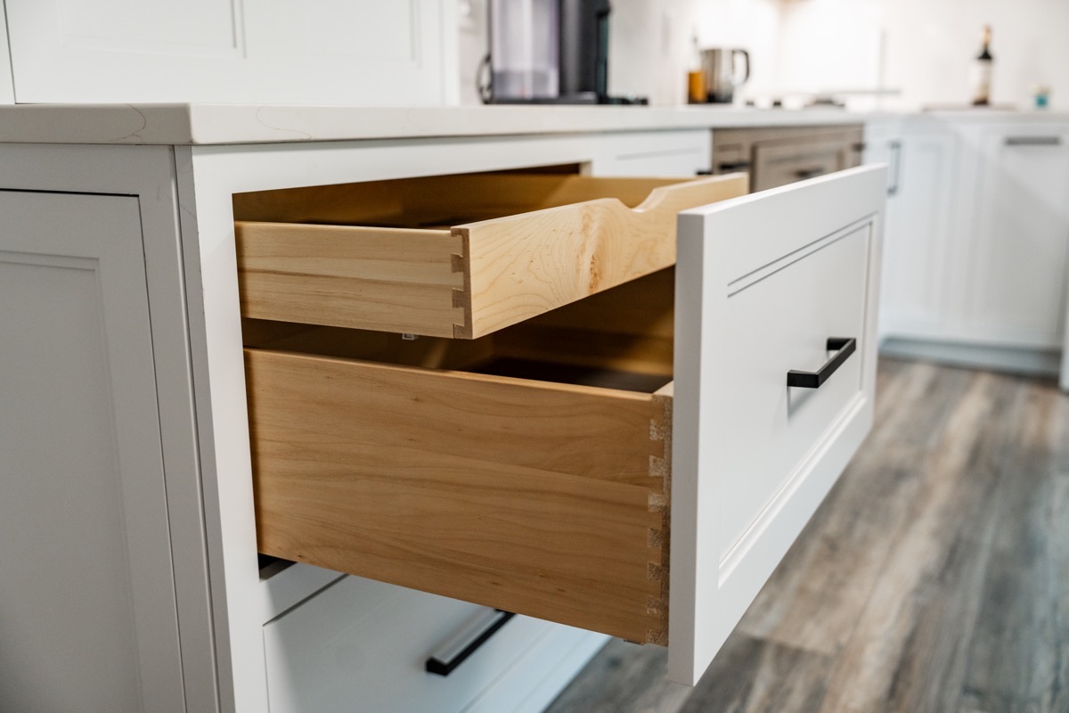 Open dovetailed wood drawer detail at the Bethesda Cabinets showroom in a white Shiloh cabinet.