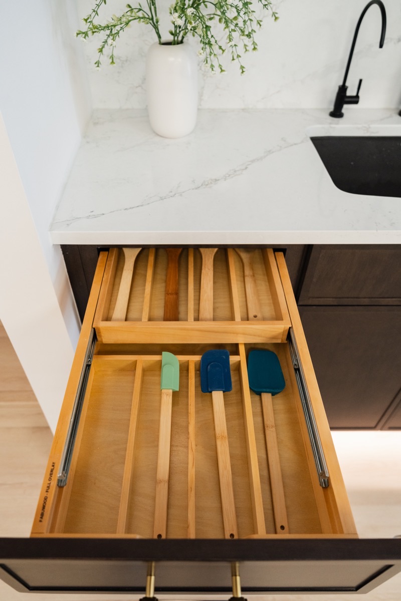 Kitchen drawer fitted with a wood organizer insert at the Bethesda Cabinets showroom in Bethesda, MD.
