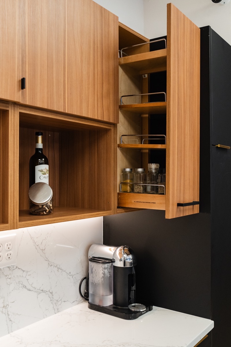 Tall pantry cabinet with wood shelving at the Bethesda Cabinets showroom in Bethesda, MD.